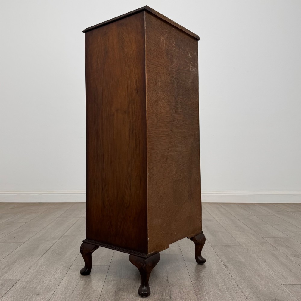 A tall, narrow dark brown burr walnut chest of drawers featuring brass handles and carved cabriole legs. View IV