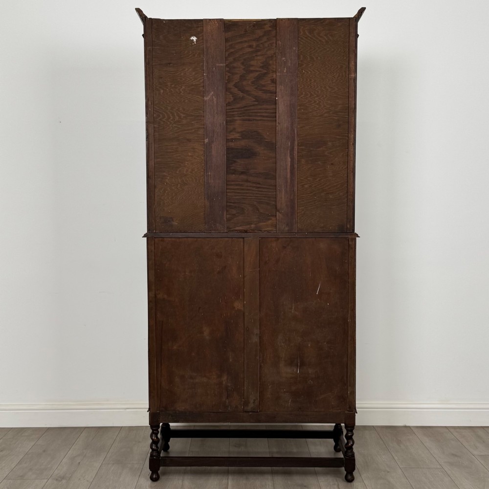 A tall 20th-century Jacobean Revival dark oak bureau bookcase with a leaded glass cabinet above a slant-front writing desk and three lower drawers. View VII