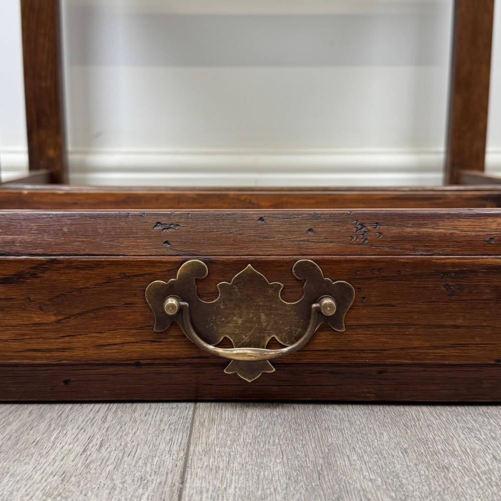 A small dark oak side table featuring a single drawer with a brass handle, turned front legs, and lower stretchers. View XI