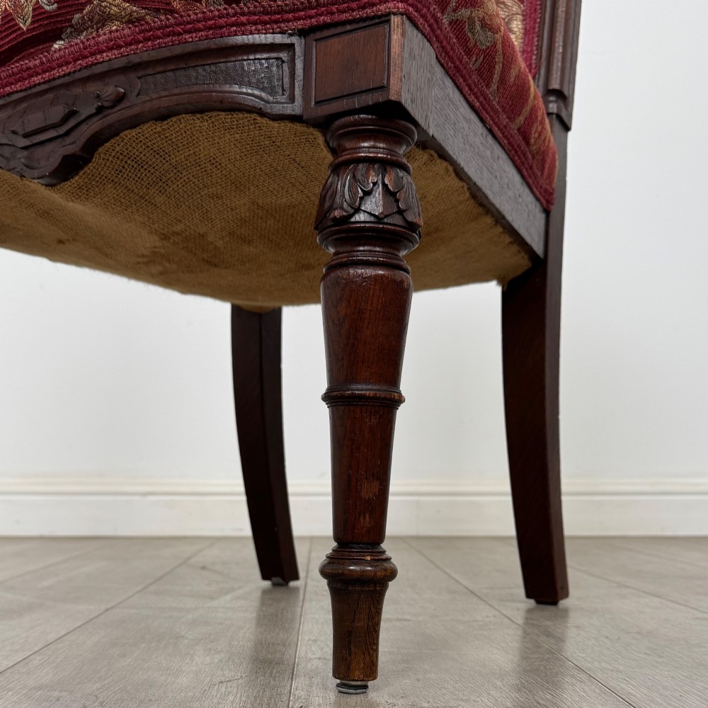 A set of six antique 19th-century Victorian oak dining chairs featuring carved crest rails and red patterned fabric upholstery. View VI