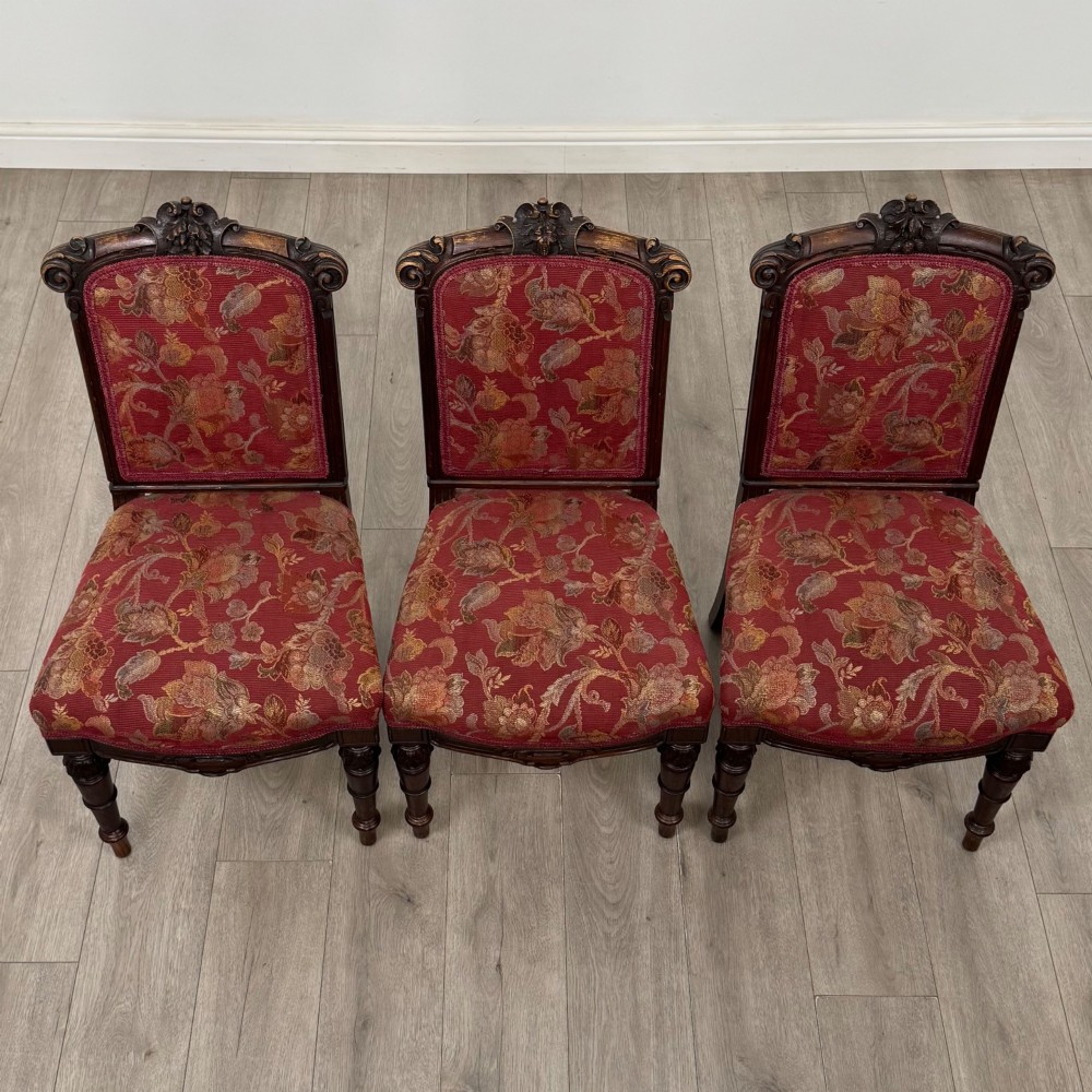 A set of six antique 19th-century Victorian oak dining chairs featuring carved crest rails and red patterned fabric upholstery. View VIII