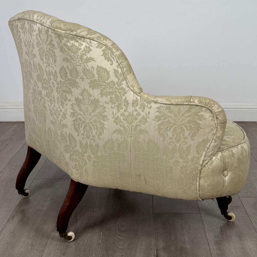 A 19th-century Victorian settee upholstered in sage green patterned damask with button-tufting and carved dark mahogany legs on ceramic castors. View VI