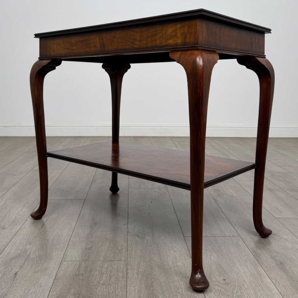 An Edwardian burr walnut side table featuring sloped cabriole legs, pad feet, a deep frieze, and a lower undertier shelf. View II