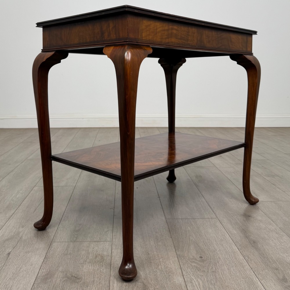 An Edwardian burr walnut side table featuring sloped cabriole legs, pad feet, a deep frieze, and a lower undertier shelf. View IV