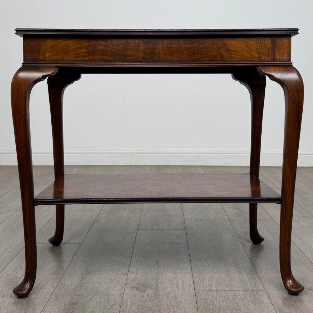 An Edwardian burr walnut side table featuring sloped cabriole legs, pad feet, a deep frieze, and a lower undertier shelf. View V
