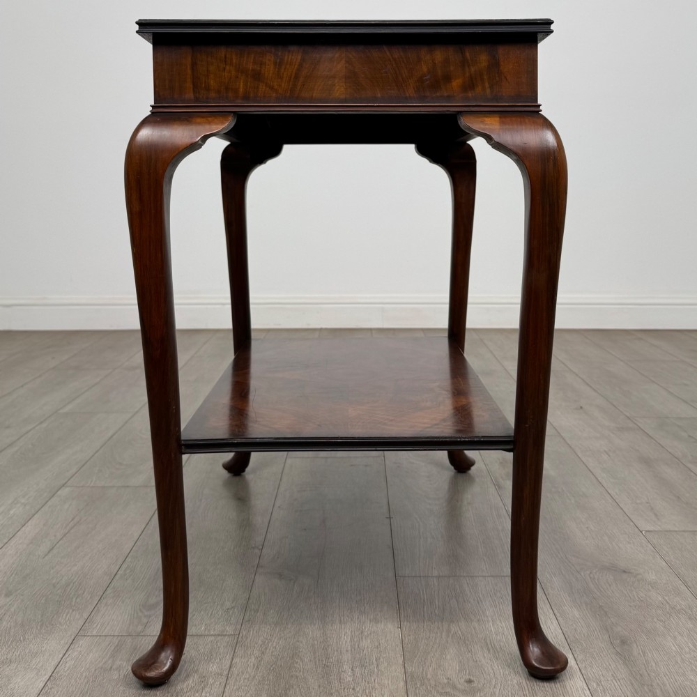 An Edwardian burr walnut side table featuring sloped cabriole legs, pad feet, a deep frieze, and a lower undertier shelf. View VII
