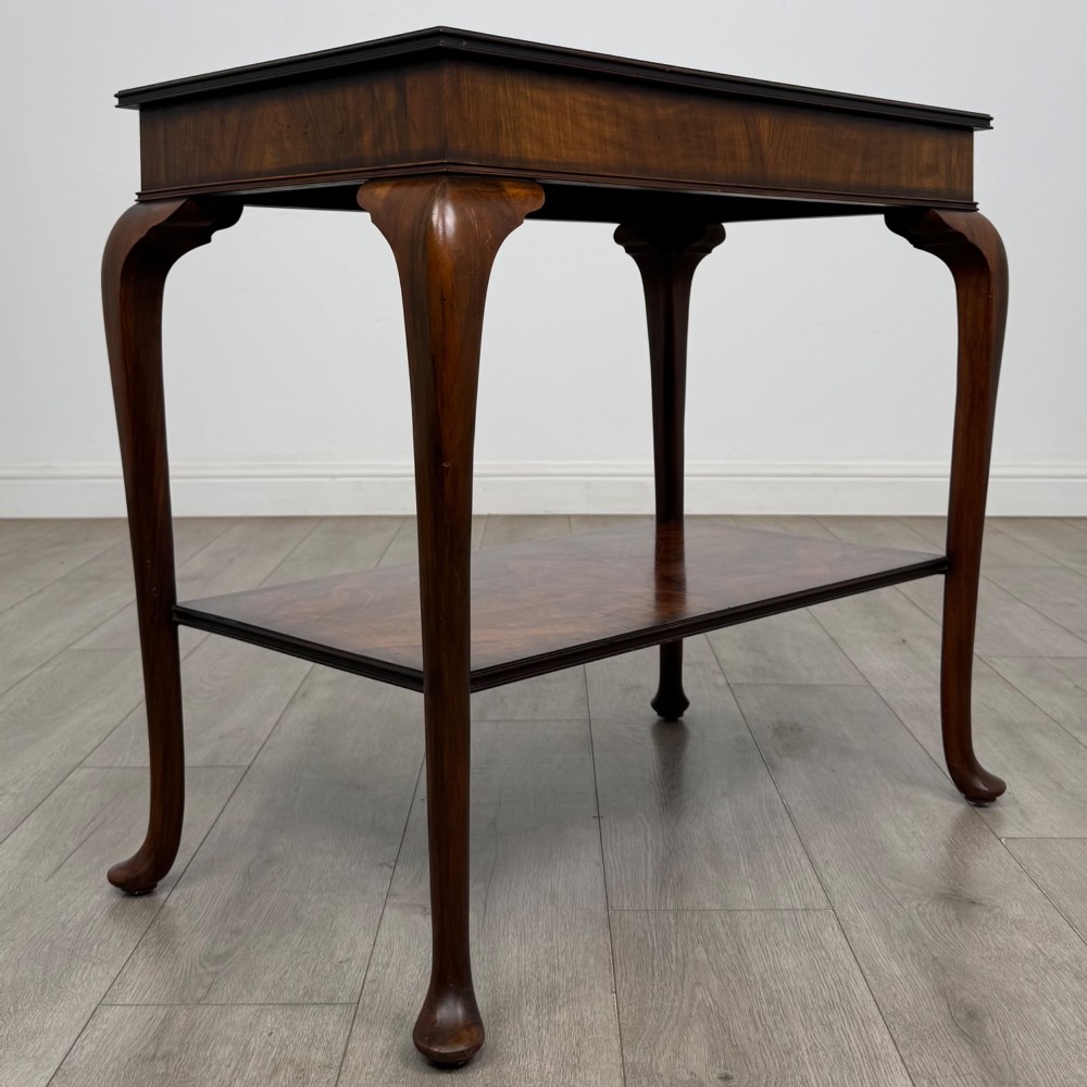 An Edwardian burr walnut side table featuring sloped cabriole legs, pad feet, a deep frieze, and a lower undertier shelf. View VIII
