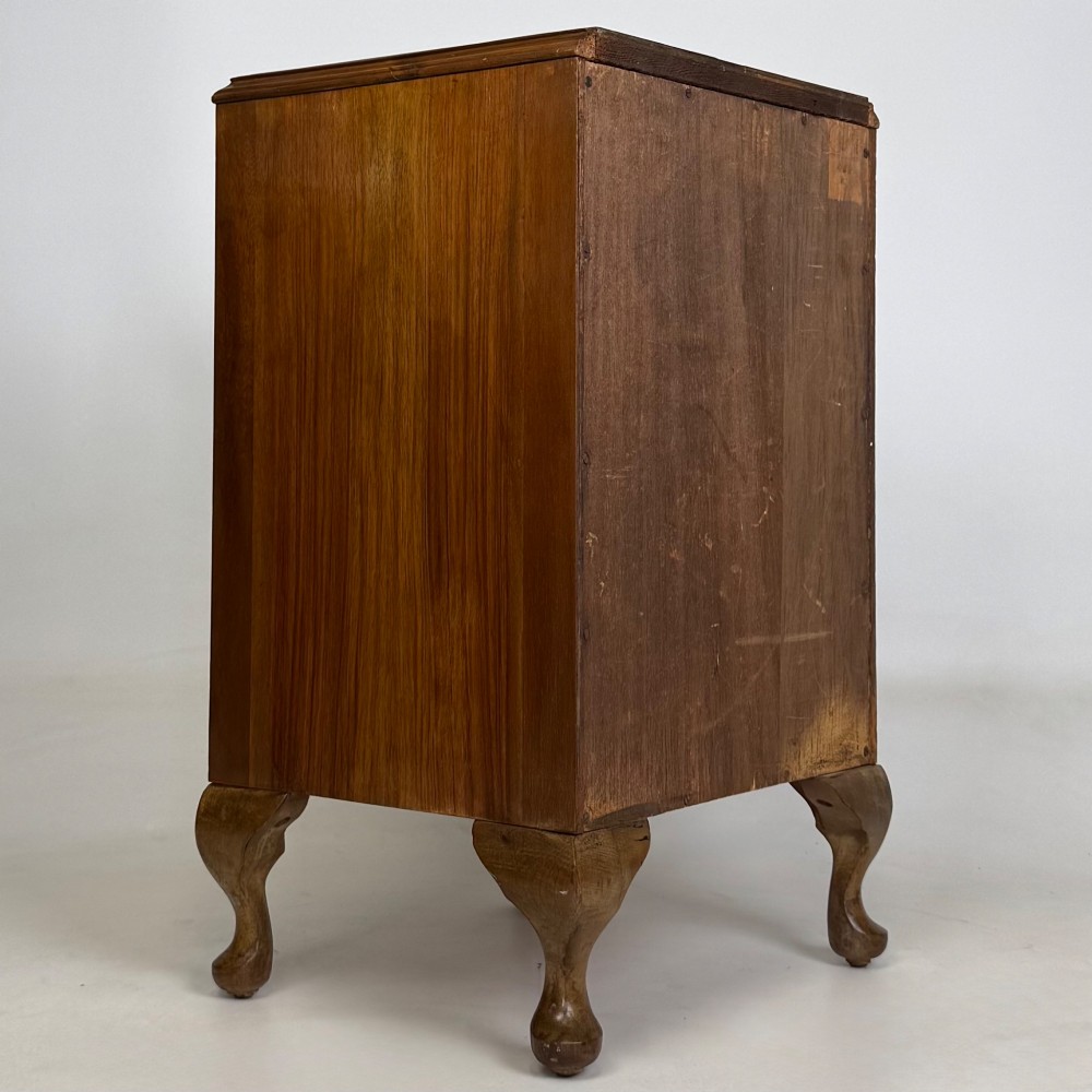 A pair of warm brown walnut bedside cabinets featuring single door cupboards, small round knobs, and carved cabriole legs with pad feet. View VI