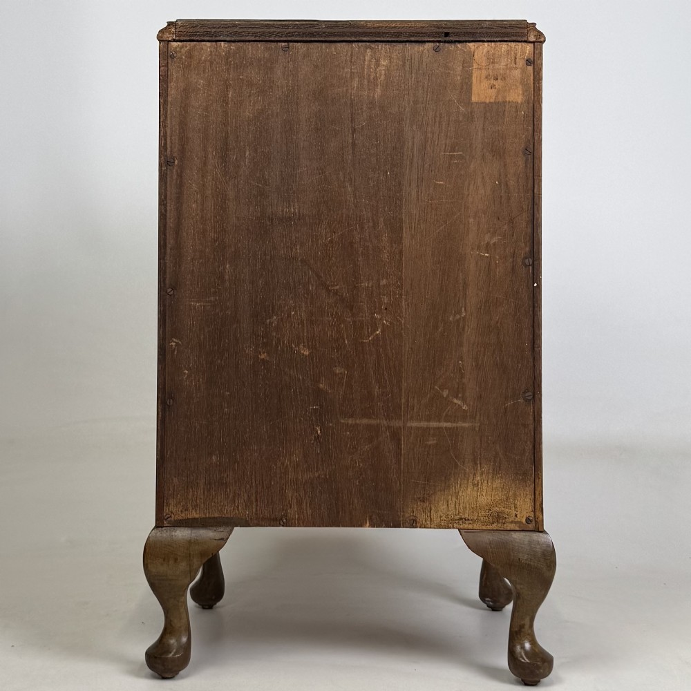 A pair of warm brown walnut bedside cabinets featuring single door cupboards, small round knobs, and carved cabriole legs with pad feet. View VII
