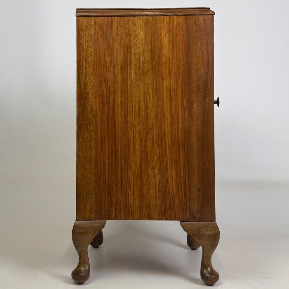 A pair of warm brown walnut bedside cabinets featuring single door cupboards, small round knobs, and carved cabriole legs with pad feet. View IX