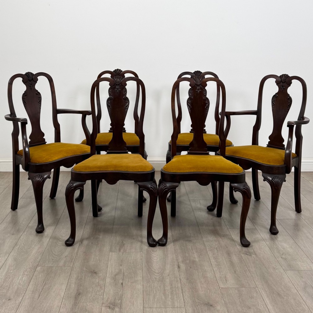 A set of six dark mahogany dining chairs featuring cabriole legs, carved back splats, and gold velvet drop-in seats.