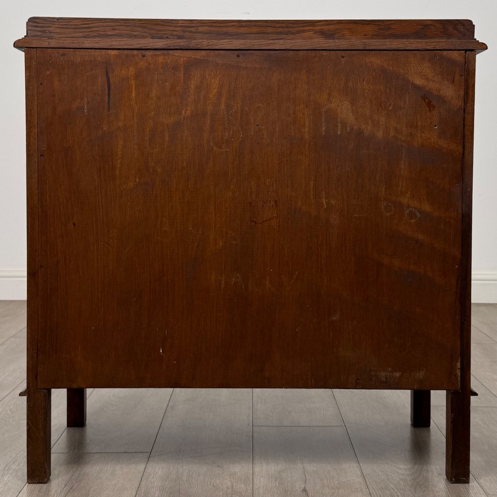 An Edwardian warm brown oak fitted cupboard featuring twin recessed panel doors, a central wooden latch, and four straight legs. View VI