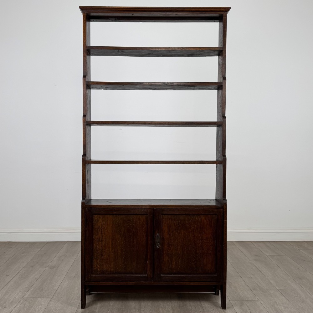 A tall dark oak open bookcase featuring multiple upper shelves and a two-door lower cupboard base. View II