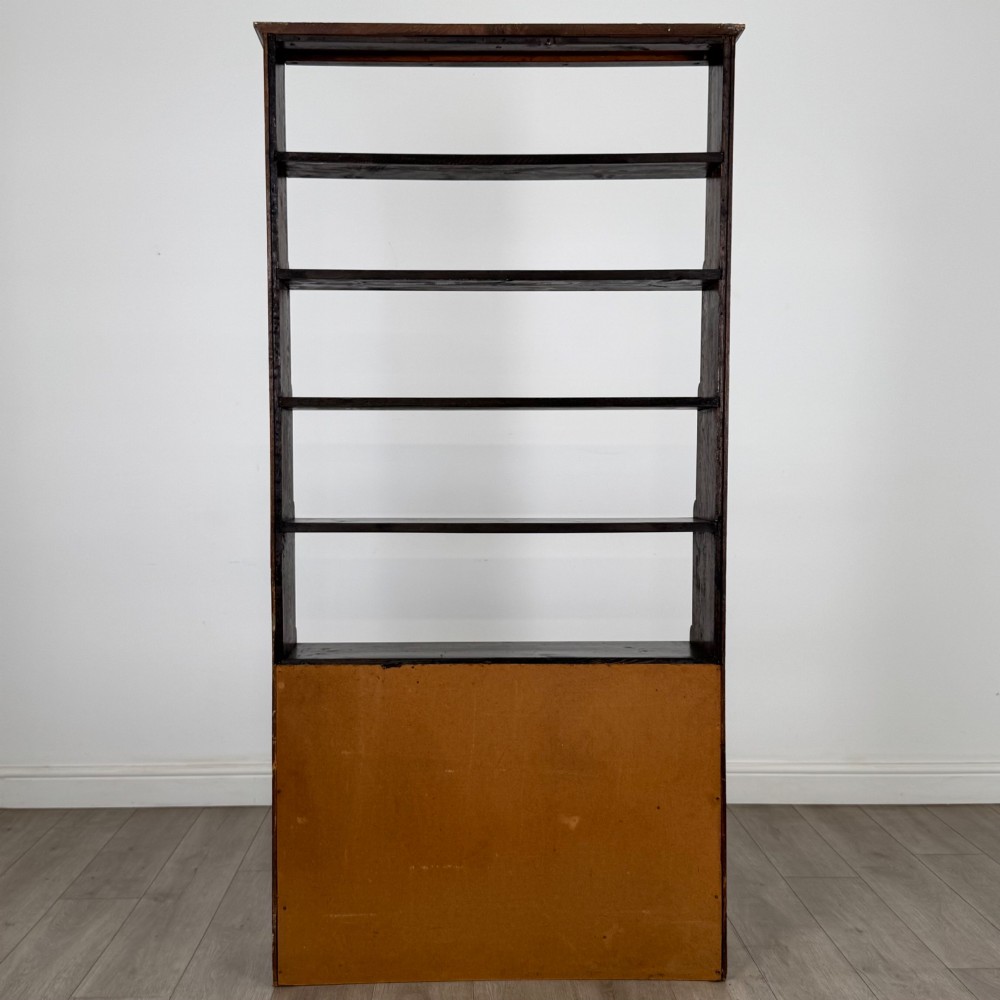 A tall dark oak open bookcase featuring multiple upper shelves and a two-door lower cupboard base. View VII