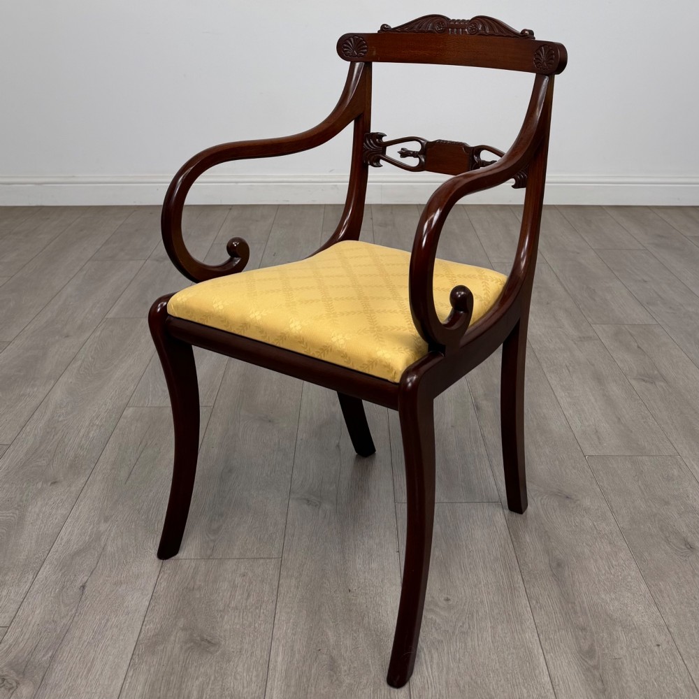 A set of ten mahogany Regency style dining chairs with yellow upholstered seats, including eight side chairs and two carvers with scrolling arms. View V