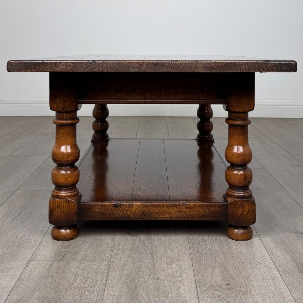 A rectangular dark oak coffee table featuring turned baluster legs and a full-length lower shelf. View III