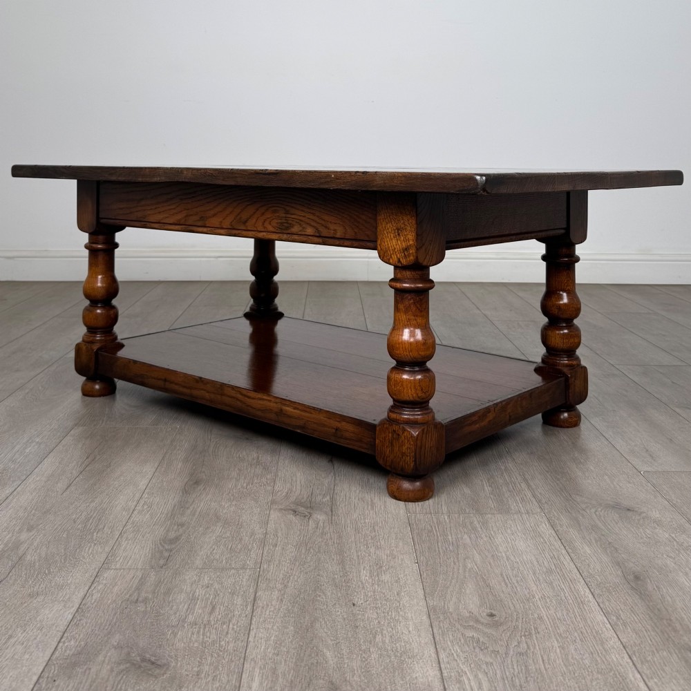 A rectangular dark oak coffee table featuring turned baluster legs and a full-length lower shelf. View VI
