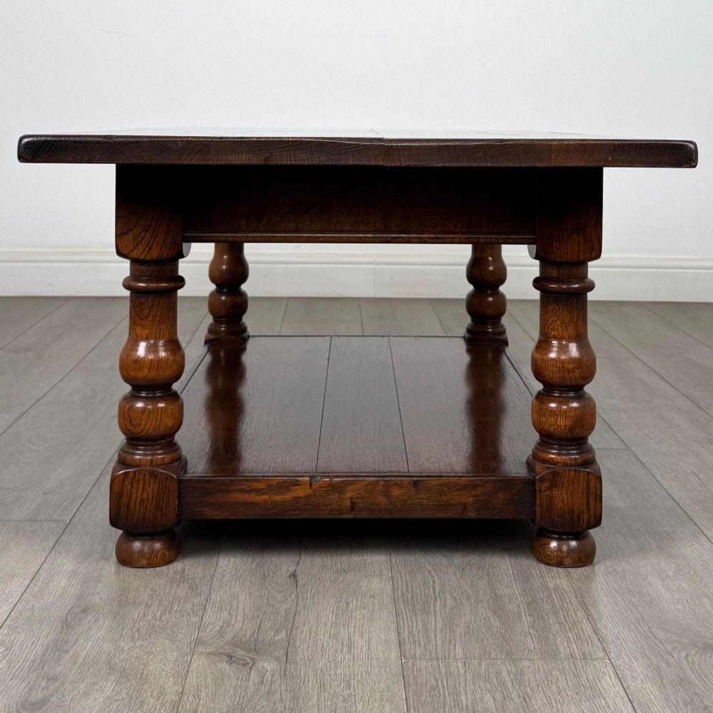 A rectangular dark oak coffee table featuring turned baluster legs and a full-length lower shelf. View VII