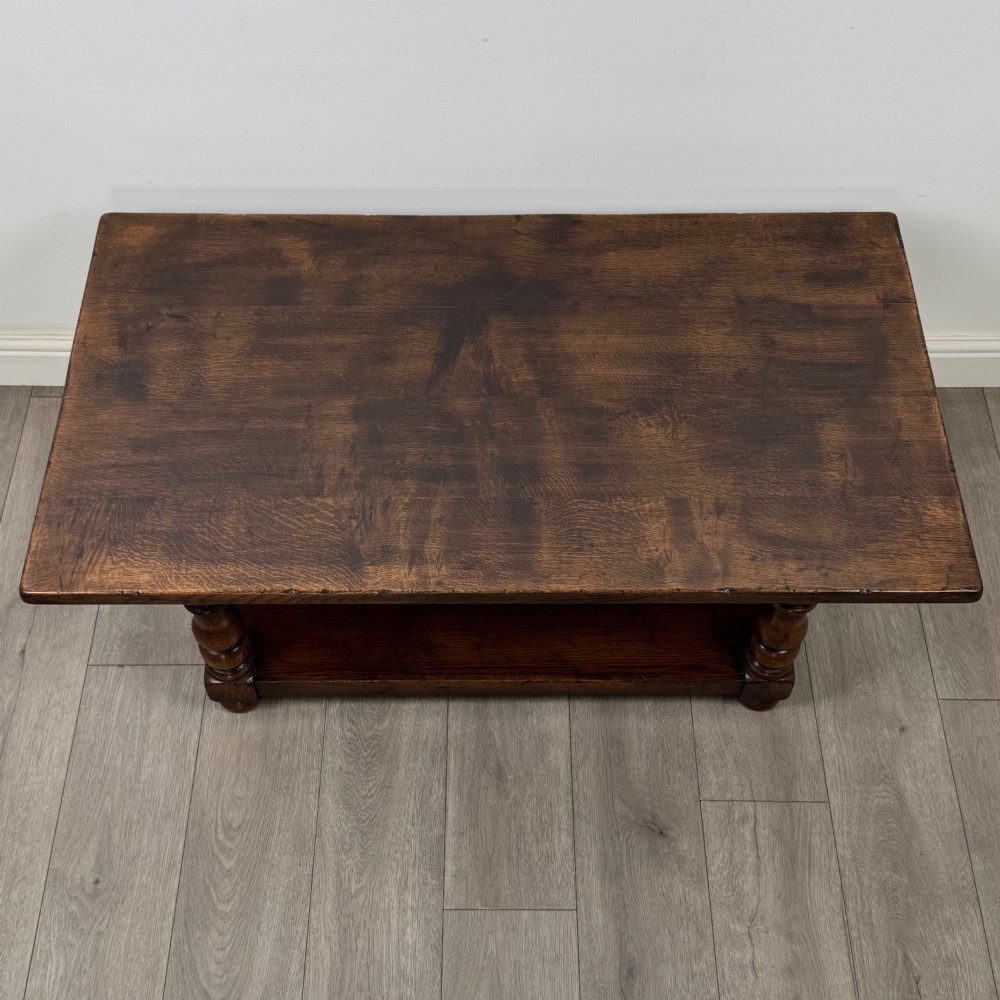 A rectangular dark oak coffee table featuring turned baluster legs and a full-length lower shelf. View IX