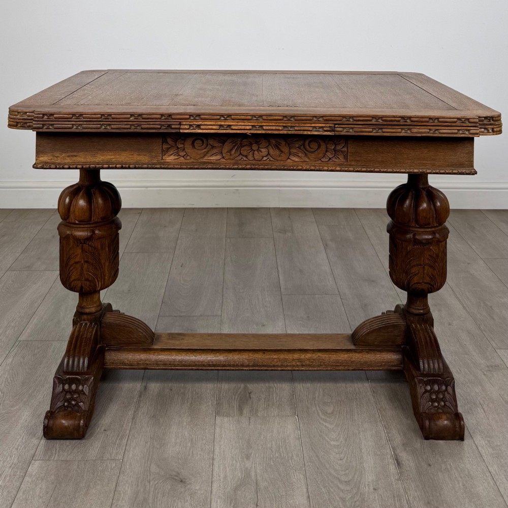 An antique Edwardian oak draw-leaf dining table featuring carved bulbous supports and a central stretcher. View IV