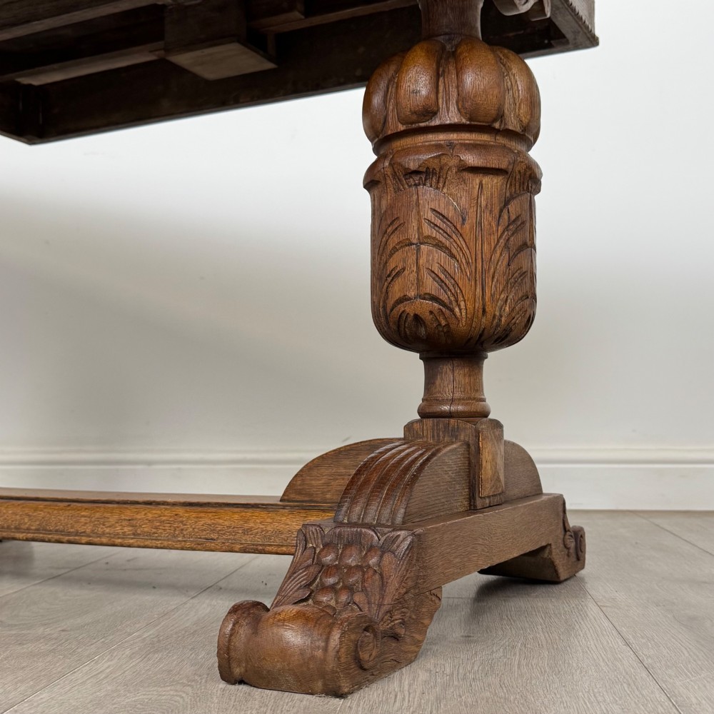 An antique Edwardian oak draw-leaf dining table featuring carved bulbous supports and a central stretcher. View VII