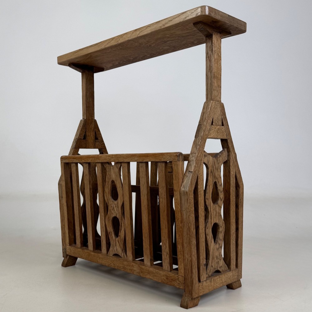 An antique Arts and Crafts oak side table featuring a rectangular top supported by slender uprights above a slatted lower magazine trough. View II