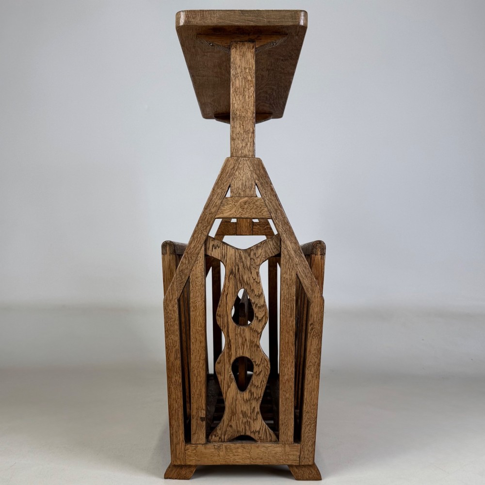 An antique Arts and Crafts oak side table featuring a rectangular top supported by slender uprights above a slatted lower magazine trough. View III