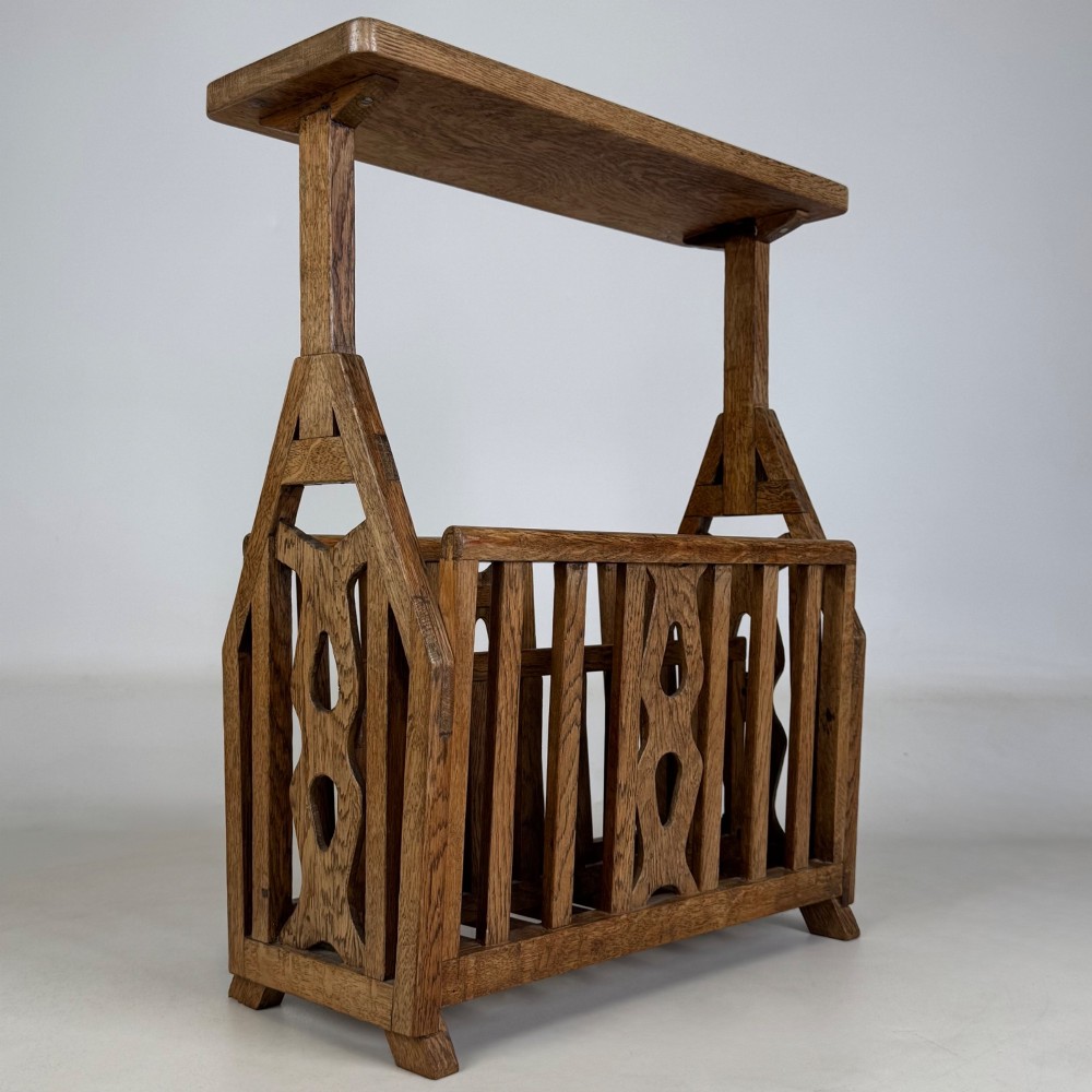 An antique Arts and Crafts oak side table featuring a rectangular top supported by slender uprights above a slatted lower magazine trough. View IV