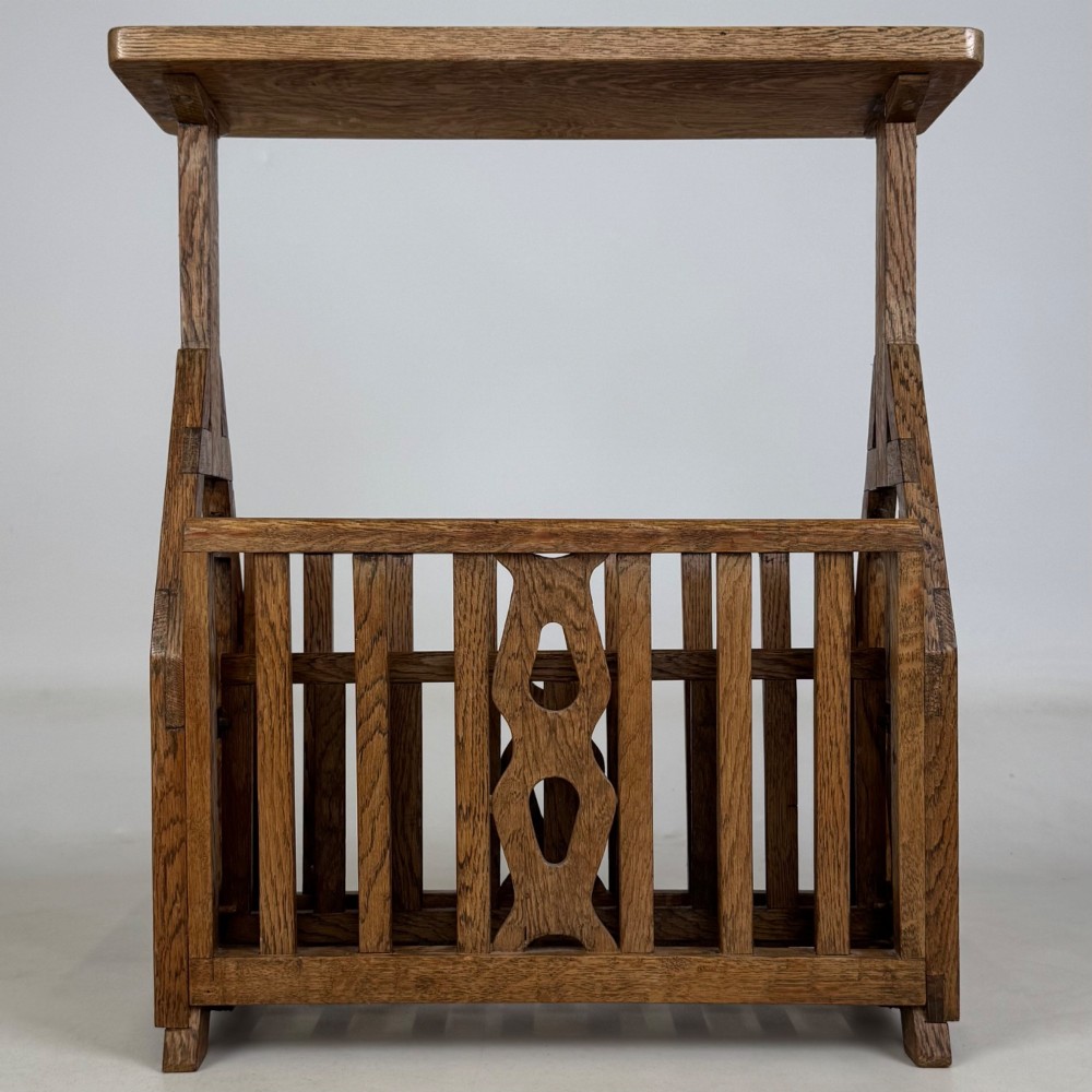An antique Arts and Crafts oak side table featuring a rectangular top supported by slender uprights above a slatted lower magazine trough. View V