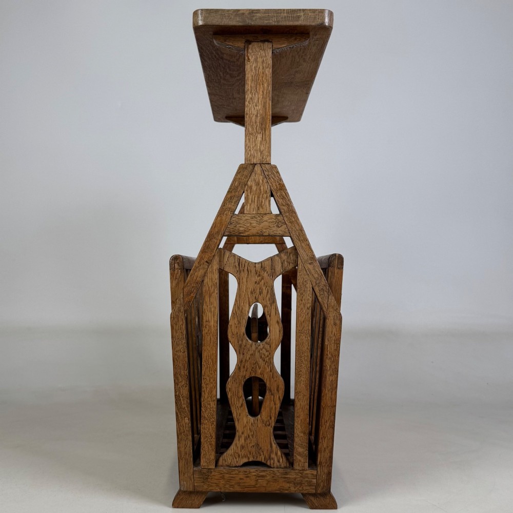 An antique Arts and Crafts oak side table featuring a rectangular top supported by slender uprights above a slatted lower magazine trough. View VII