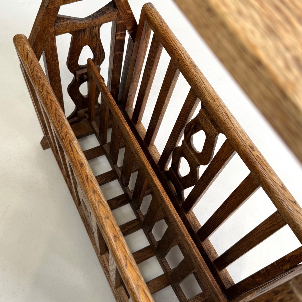An antique Arts and Crafts oak side table featuring a rectangular top supported by slender uprights above a slatted lower magazine trough. View X