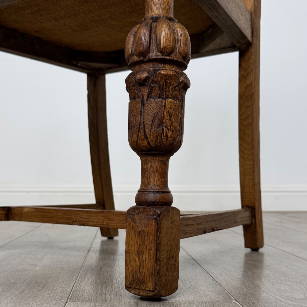 A set of four Edwardian oak dining chairs featuring carved back splats, brown upholstered seats, and bulbous turned front legs. View VI