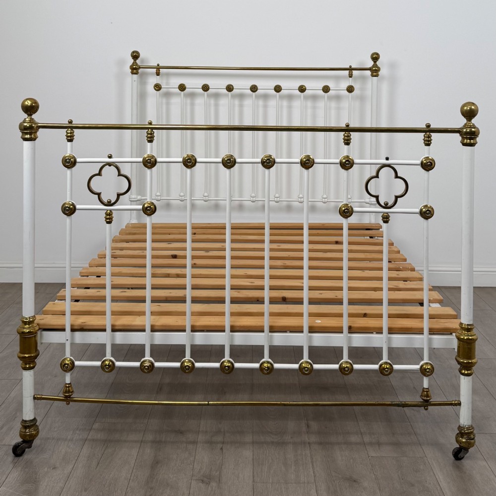 Victorian white-painted iron and polished brass king-size bedstead featuring round brass finials and quatrefoil metalwork. View IV