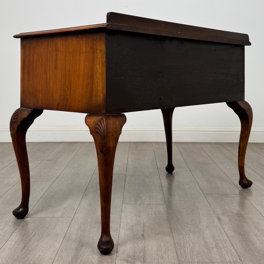 An Edwardian burr walnut writing table featuring five drawers with brass drop handles and carved cabriole legs. View IV