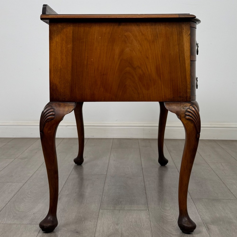 An Edwardian burr walnut writing table featuring five drawers with brass drop handles and carved cabriole legs. View VII