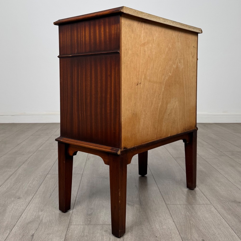 A small mahogany bedside cabinet with a top drawer, brass ring pull handles, an open lower shelf, and straight tapered legs. View IV