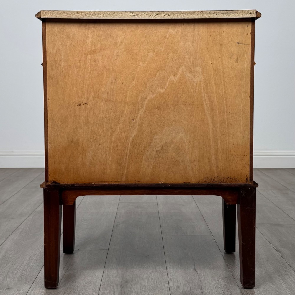 A small mahogany bedside cabinet with a top drawer, brass ring pull handles, an open lower shelf, and straight tapered legs. View V