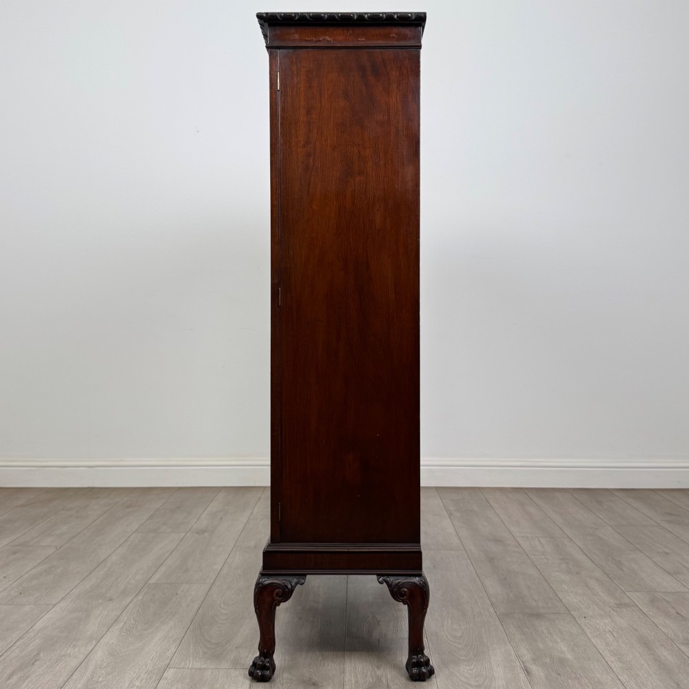 An Edwardian dark mahogany display cabinet featuring double astragal glazed doors and cabriole legs with carved claw and ball feet. View IV