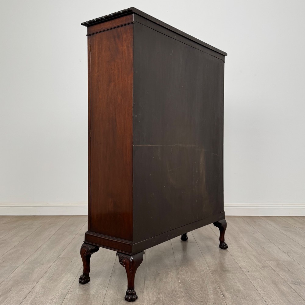 An Edwardian dark mahogany display cabinet featuring double astragal glazed doors and cabriole legs with carved claw and ball feet. View V