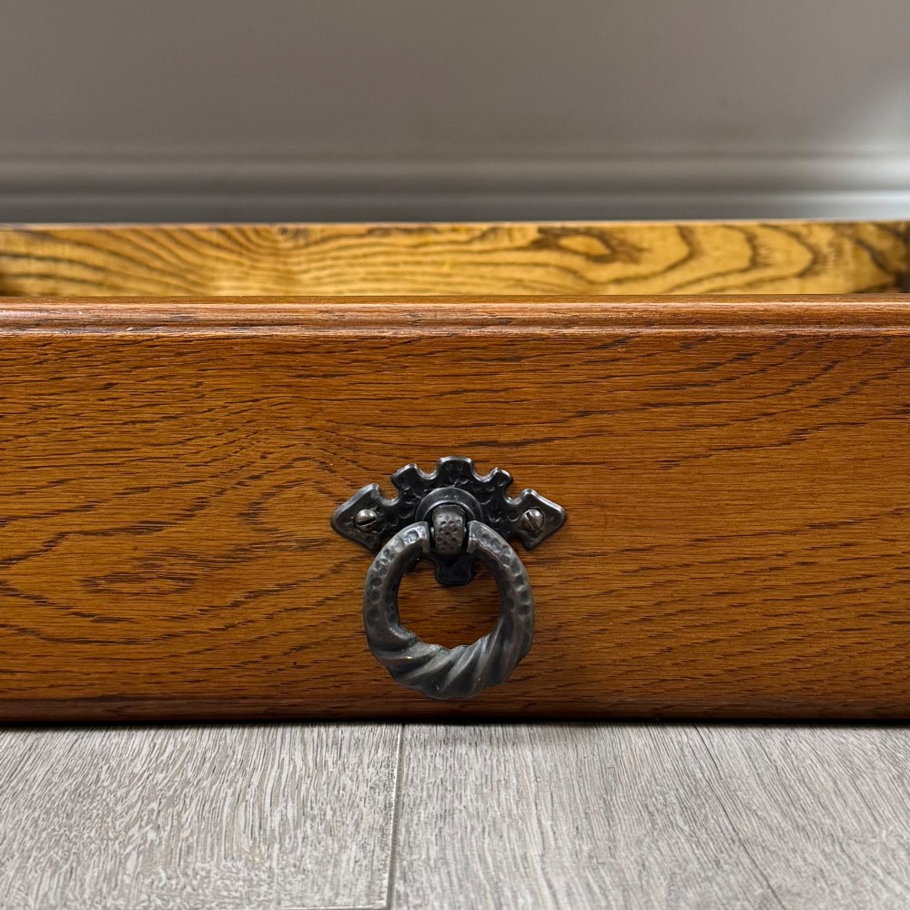 A rectangular warm brown oak coffee table featuring two drawers with metal ring handles, carved apron detailing, turned legs, and a lower storage shelf. View XI