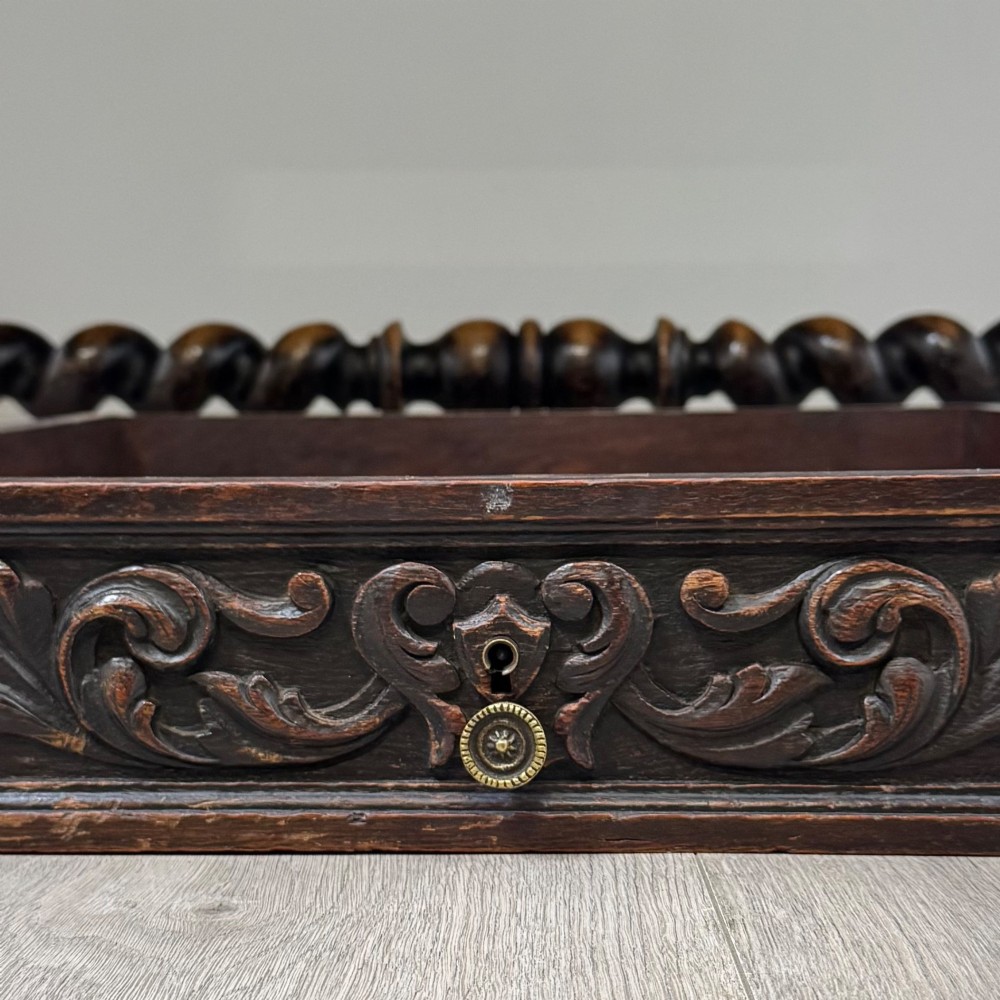A 19th-century dark oak writing table featuring carved drawer fronts, barley twist legs, and a low spiral stretcher. View XI