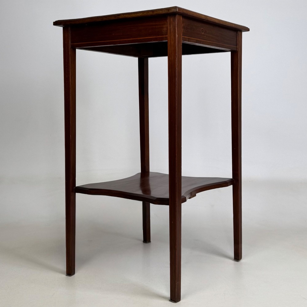 A tall Edwardian mahogany side table featuring four slender tapered legs, a square top surface, and a concave-shaped lower undertier. View IV
