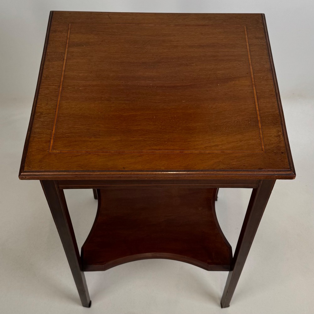 A tall Edwardian mahogany side table featuring four slender tapered legs, a square top surface, and a concave-shaped lower undertier. View IX