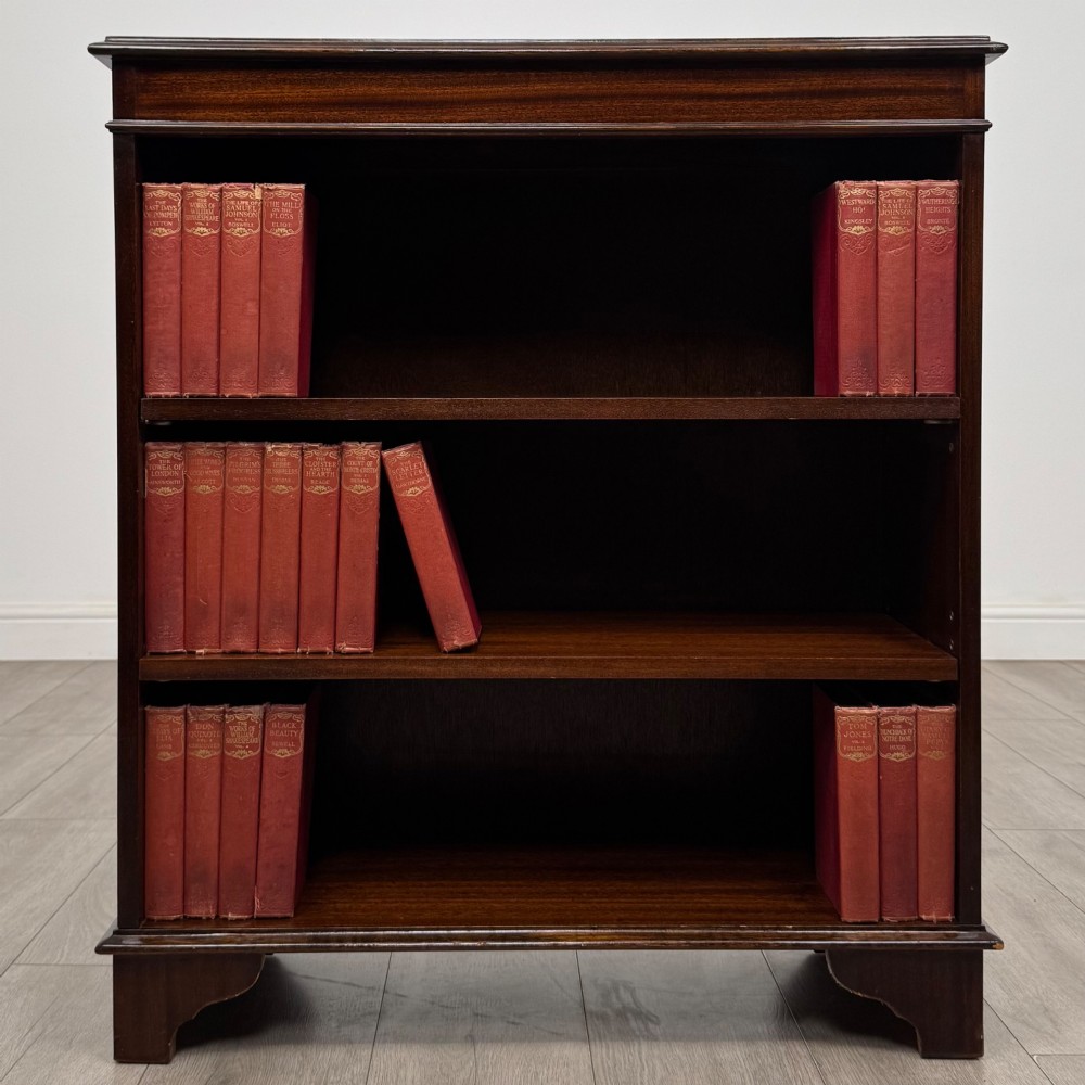 An Edwardian dark mahogany low open bookcase with three shelves and a moulded top.