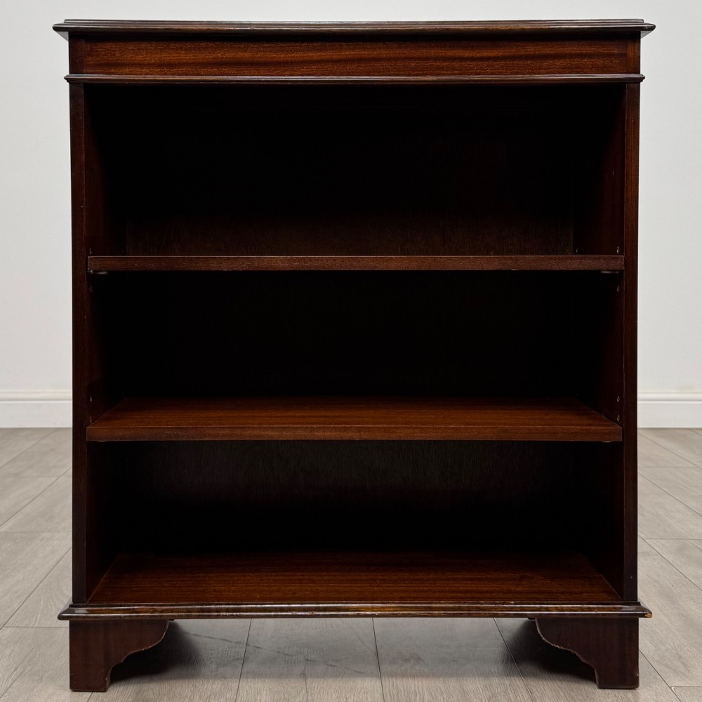An Edwardian dark mahogany low open bookcase with three shelves and a moulded top. View II