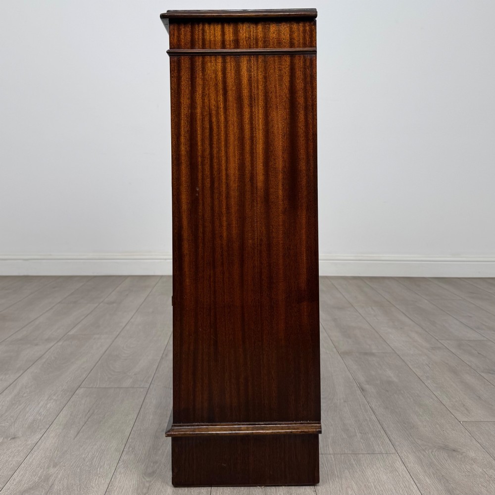 An Edwardian dark mahogany low open bookcase with three shelves and a moulded top. View IV