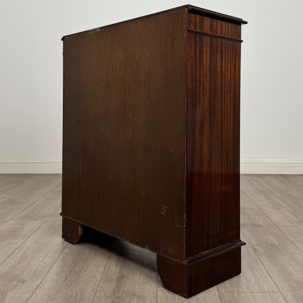 An Edwardian dark mahogany low open bookcase with three shelves and a moulded top. View VII