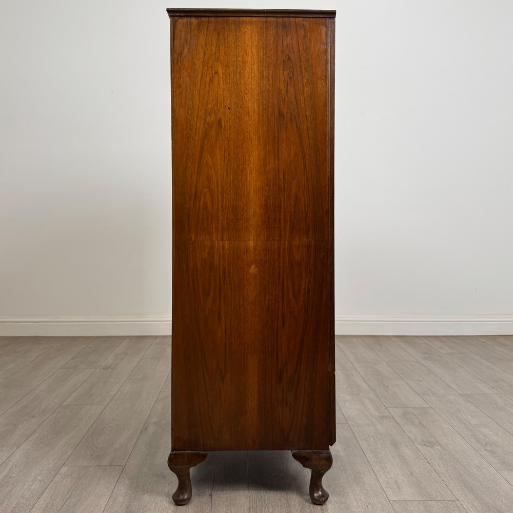 An Edwardian burr walnut storage cupboard featuring two top doors with brass strap hinges above two drawers on cabriole legs. View IV