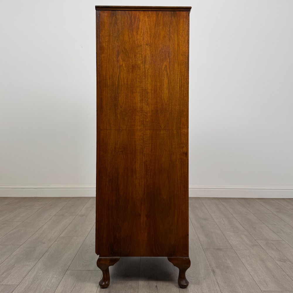 An Edwardian burr walnut storage cupboard featuring two top doors with brass strap hinges above two drawers on cabriole legs. View VIII