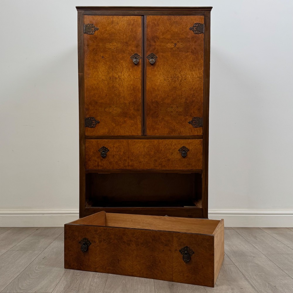 An Edwardian burr walnut storage cupboard featuring two top doors with brass strap hinges above two drawers on cabriole legs. View XI